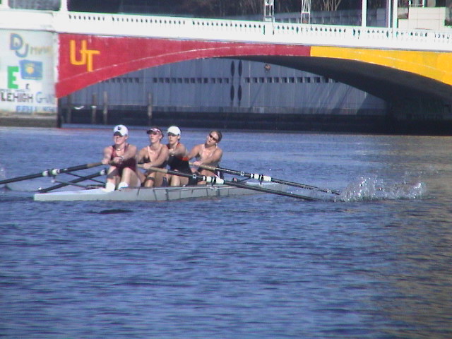 A group of people rowing a boat in the water