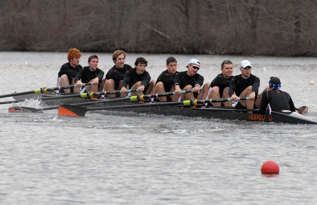 A group of people rowing a boat in the water