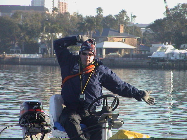 A man riding on the back of a boat in a body of water
