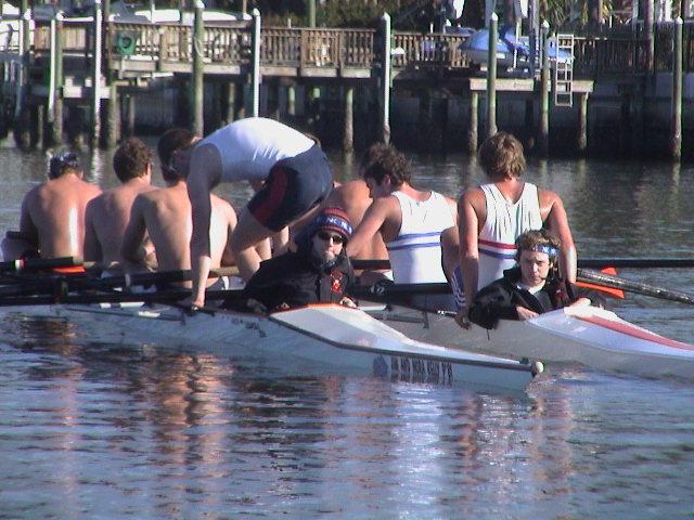 A group of people rowing a boat in the water