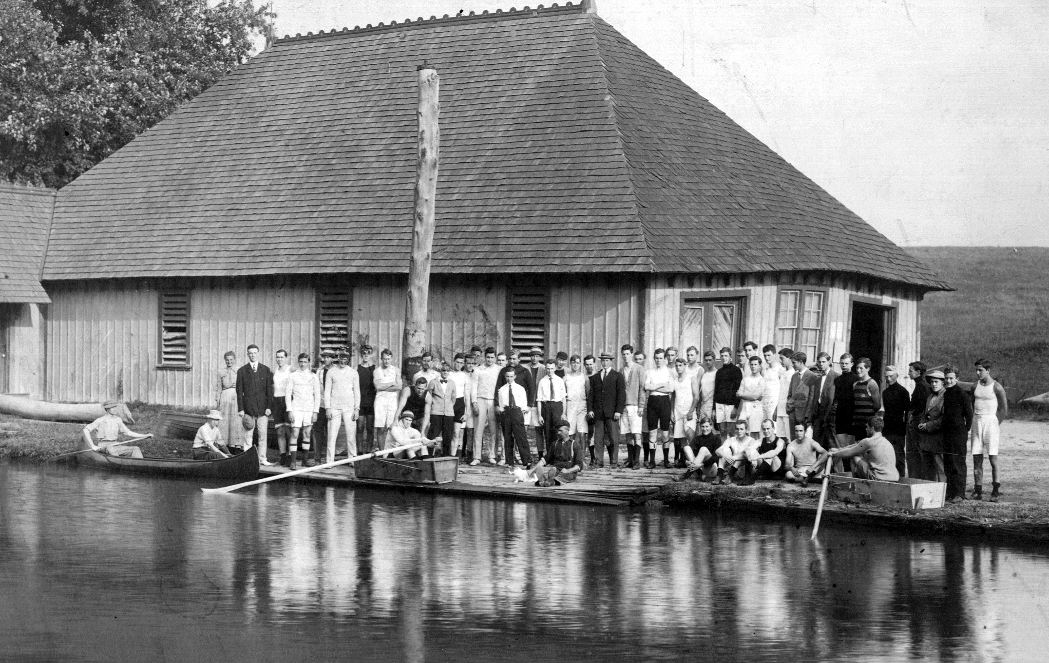 A group of people standing next to a body of water