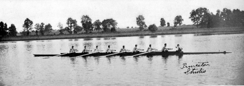 A group of people rowing a boat floating on a body of water