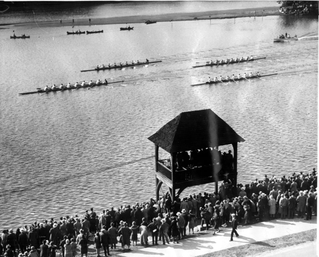 A crowd of people standing next to a body of water