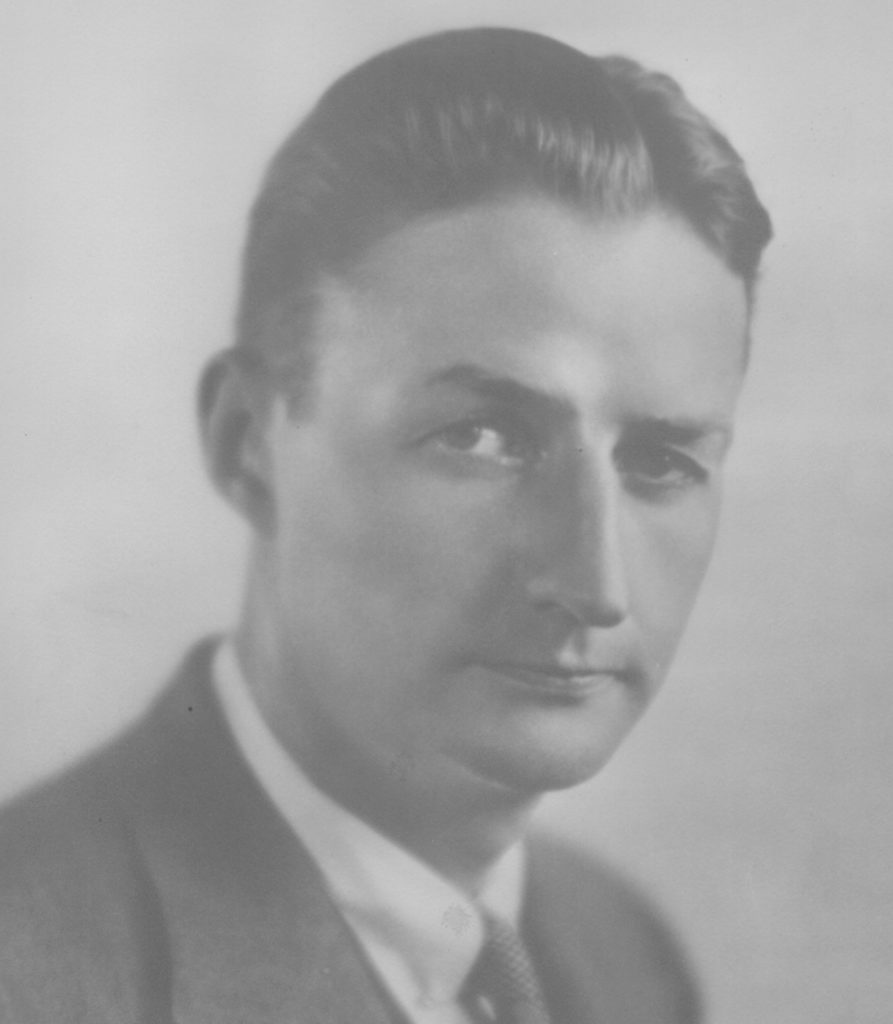 A man wearing a suit and tie looking at the camera