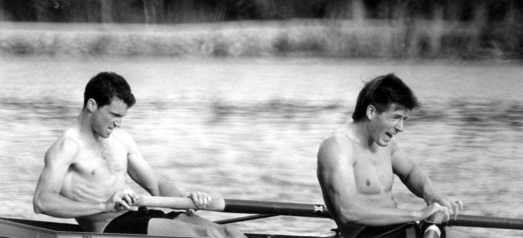 A man sitting next to a body of water