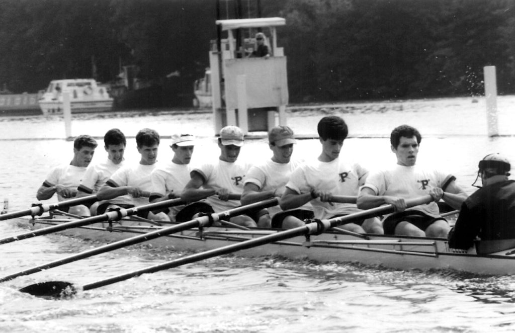 A group of people rowing a boat in the water