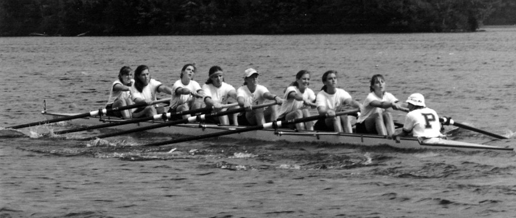 A group of people rowing a boat in a body of water