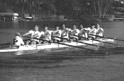 A group of people rowing a boat in the water