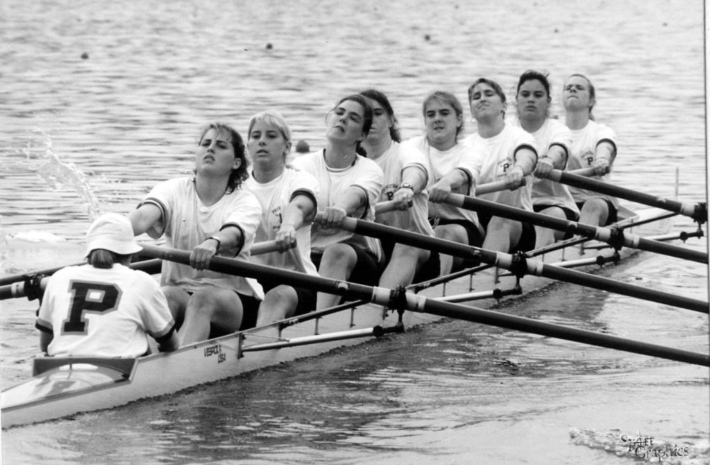 A group of people rowing a boat in the water