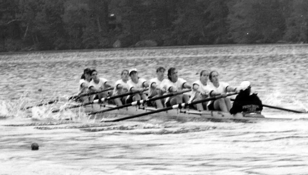 A group of people rowing a boat in the water