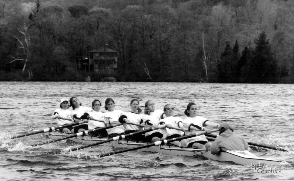 A group of people rowing a boat in a body of water