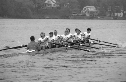 A group of people rowing a boat in the water