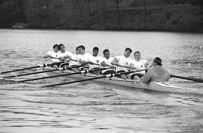 A group of people rowing a boat in the water