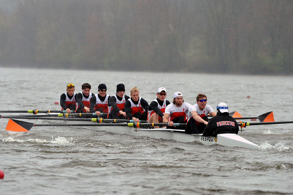 A group of people rowing a boat in a body of water