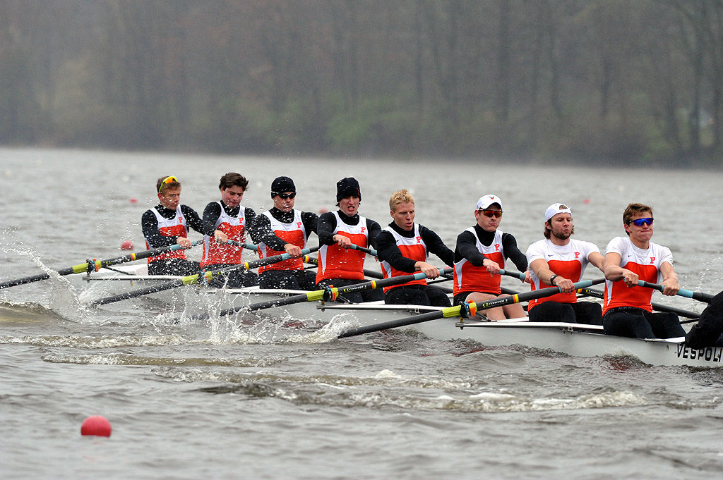 A group of people rowing a boat in a body of water