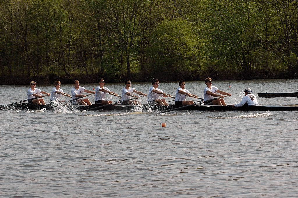 A group of people rowing a boat in a body of water