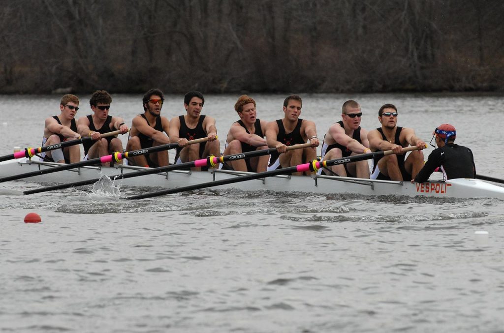 A group of people rowing a boat in the water