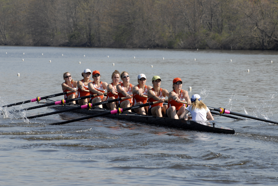 A group of people rowing a boat in a body of water