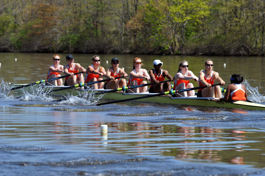 A group of people rowing a boat in the water