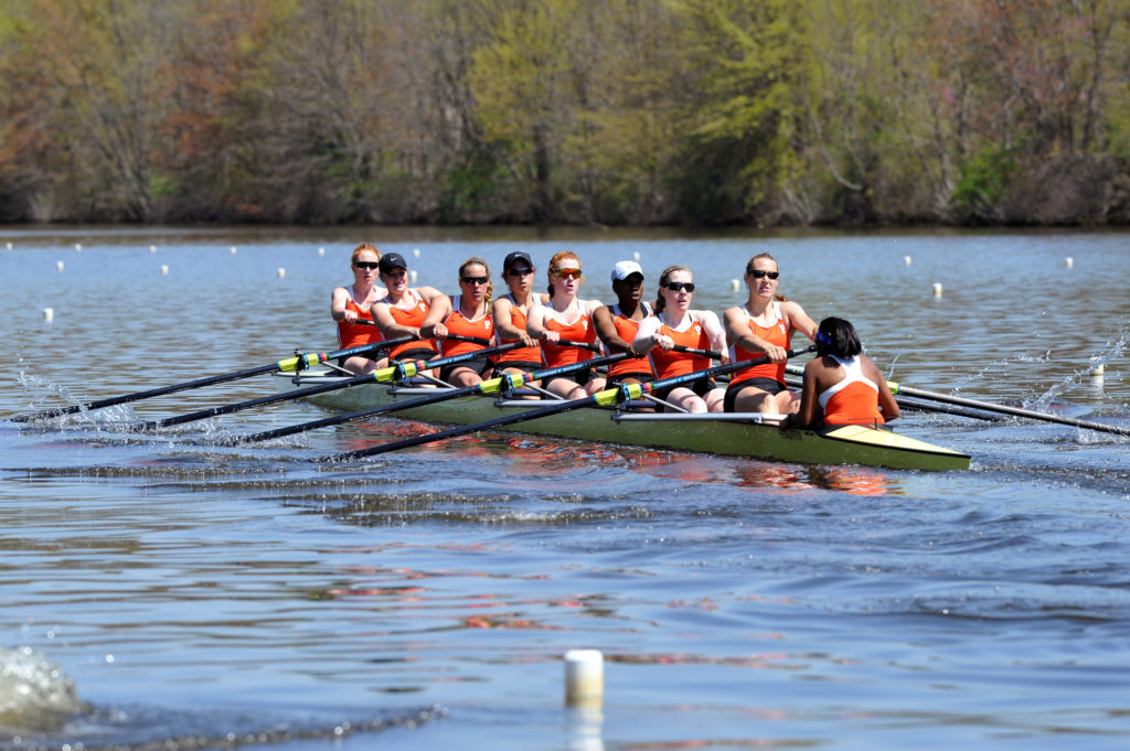 A group of people rowing a boat in a body of water