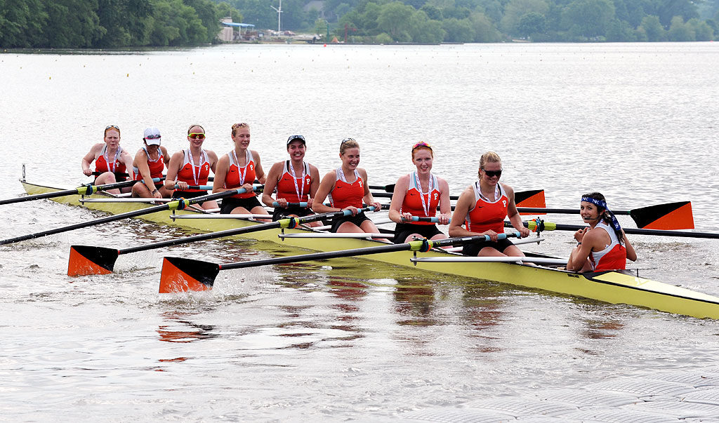 A group of people rowing a boat in a body of water