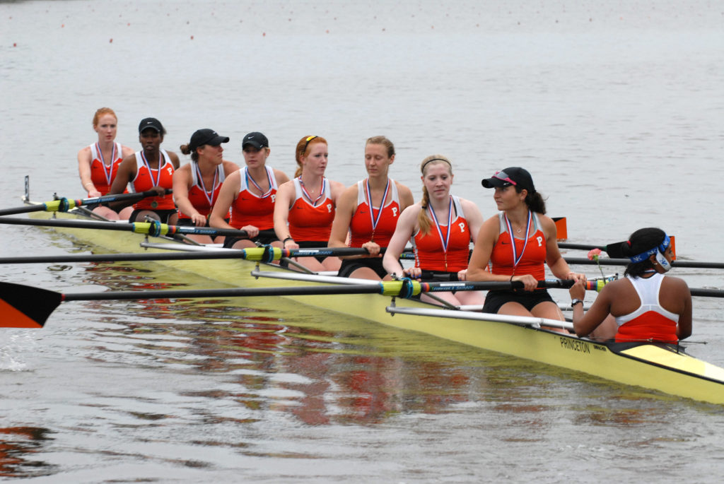 A group of people rowing a boat in the water