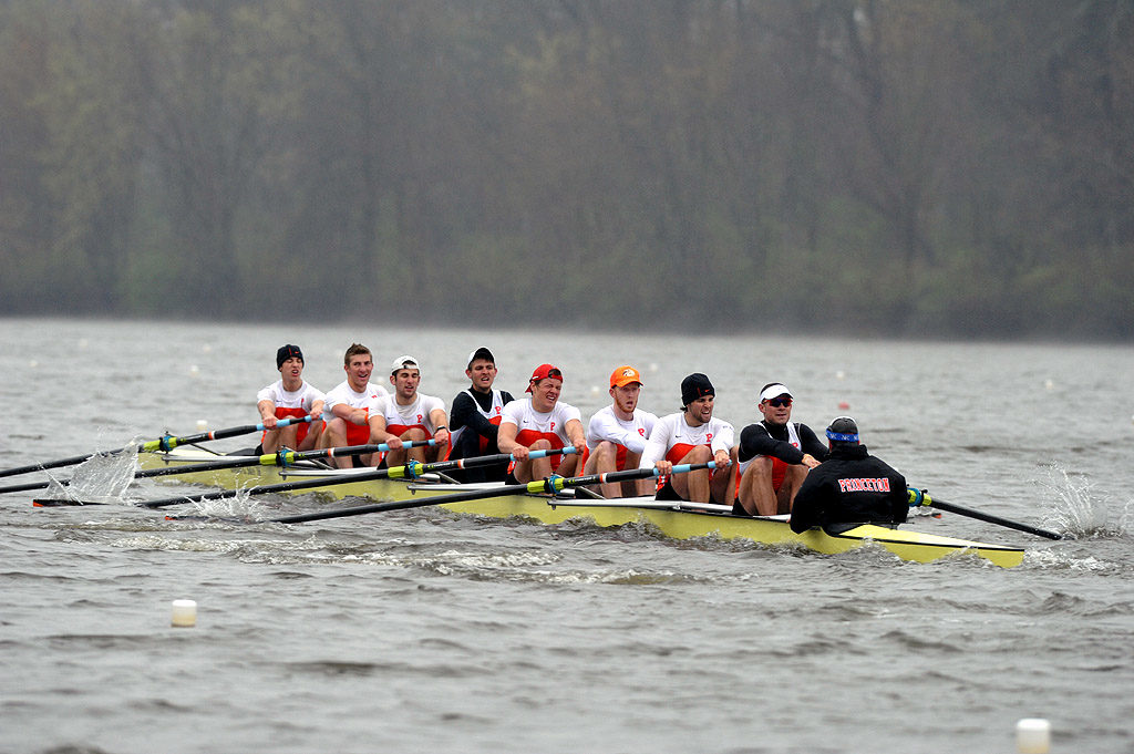 A group of people rowing a boat in a body of water