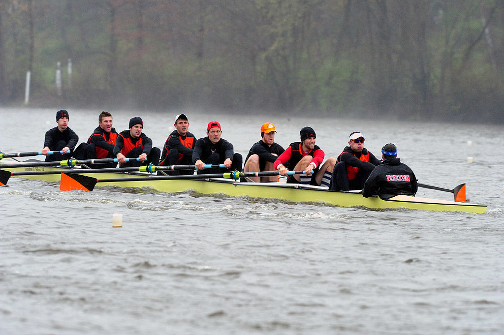 A group of people rowing a boat in a body of water