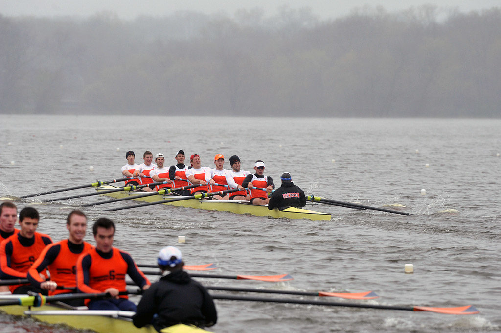 A group of people rowing a boat in a body of water