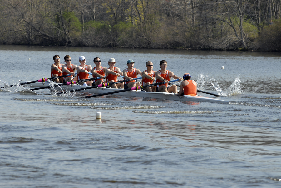 A group of people rowing a boat in a body of water