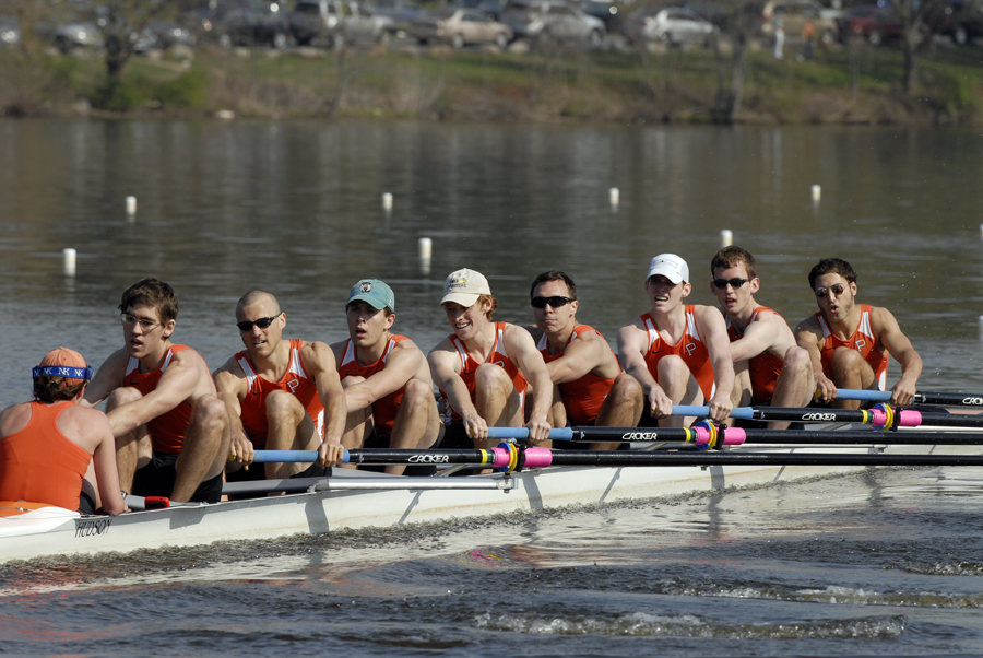 A group of people rowing a boat in a body of water