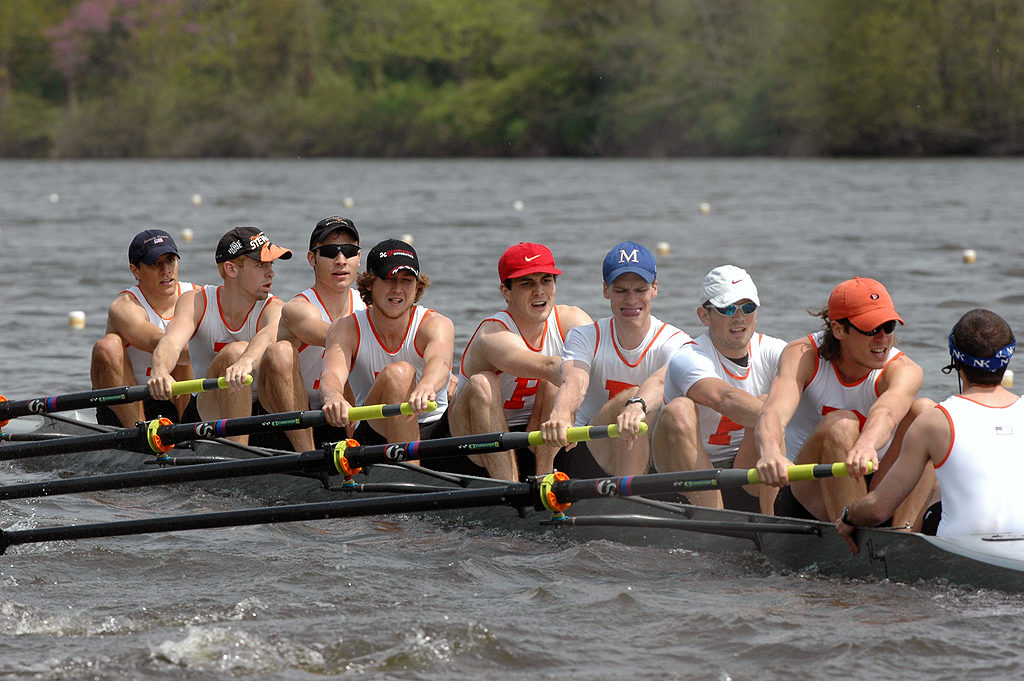 A group of people rowing a boat in the water