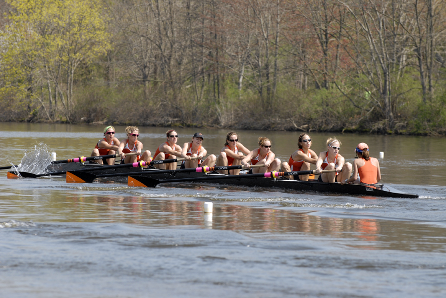 A group of people rowing a boat in a body of water