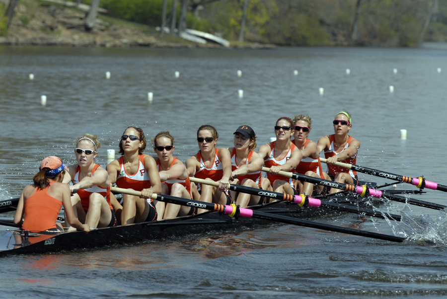 A group of people rowing a boat in a body of water