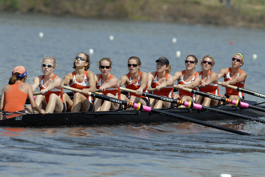 A group of people rowing a boat in a body of water