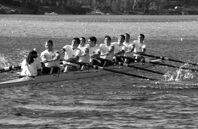 A group of people rowing a boat in a body of water