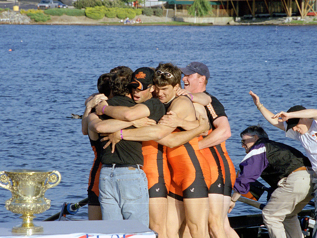 A group of people standing next to a body of water