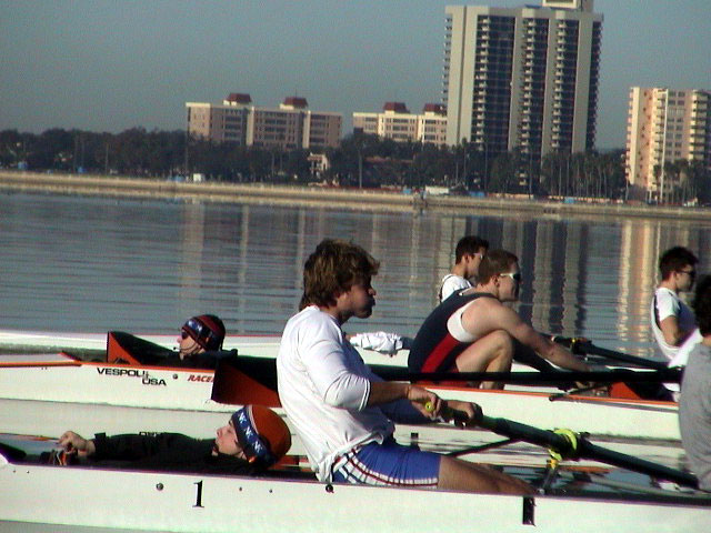 A group of people rowing a boat in the water