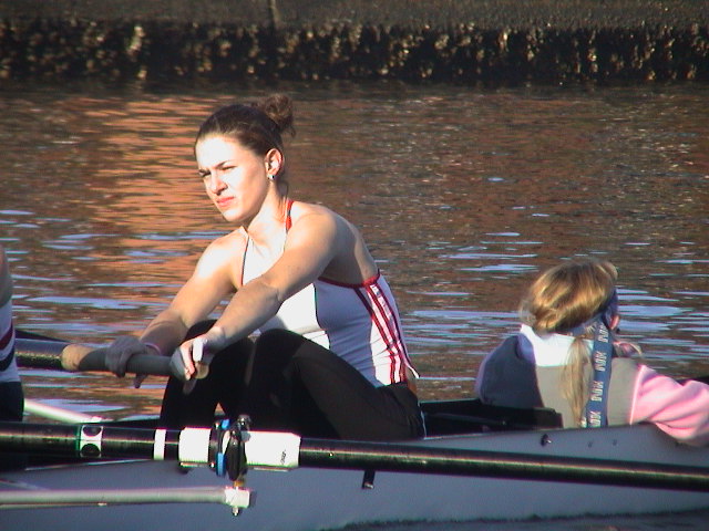 A group of people rowing a boat in the water