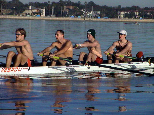 A group of people sitting next to a body of water