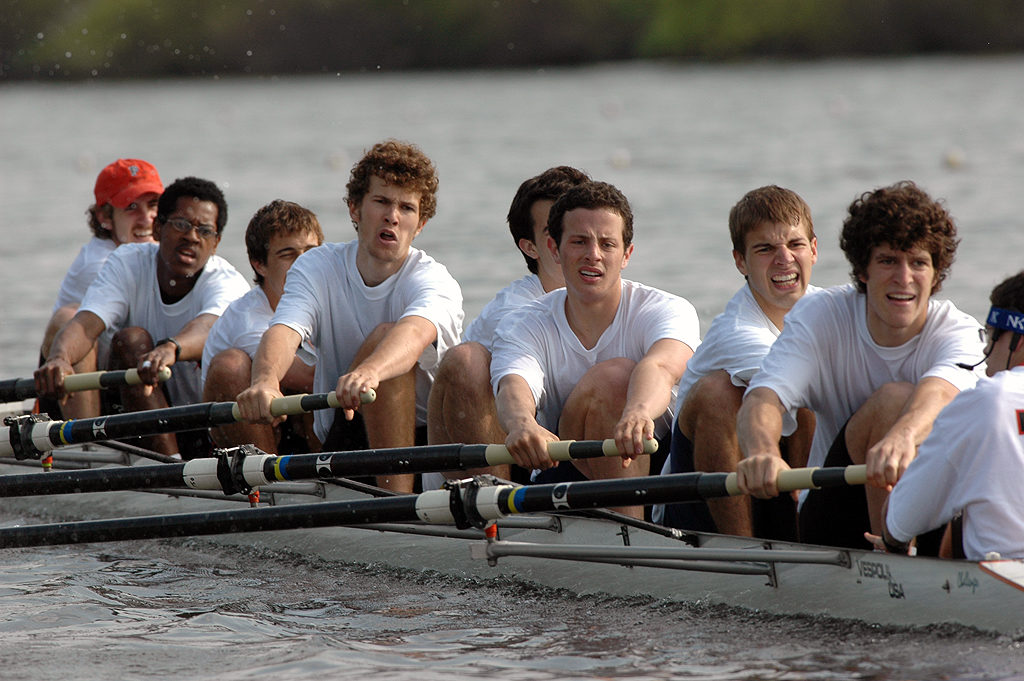 A group of people rowing a boat in the water