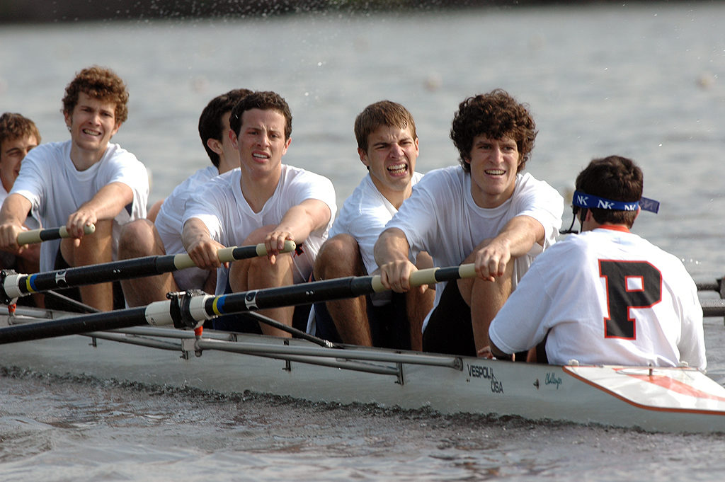 A group of people rowing a boat in the water