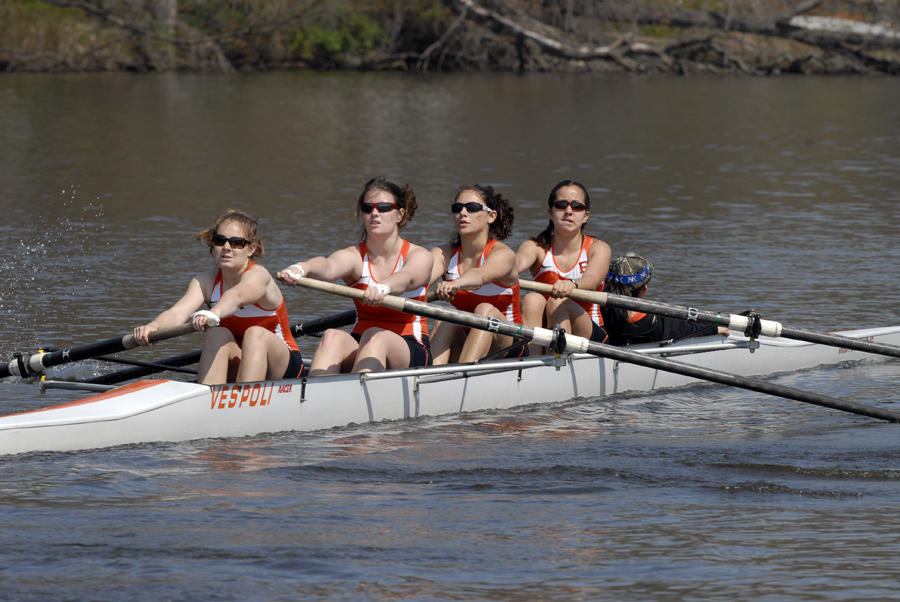 A group of people rowing a boat in a body of water