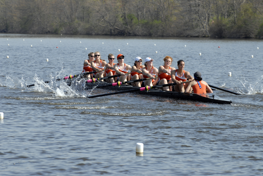 A group of people rowing a boat in a large body of water