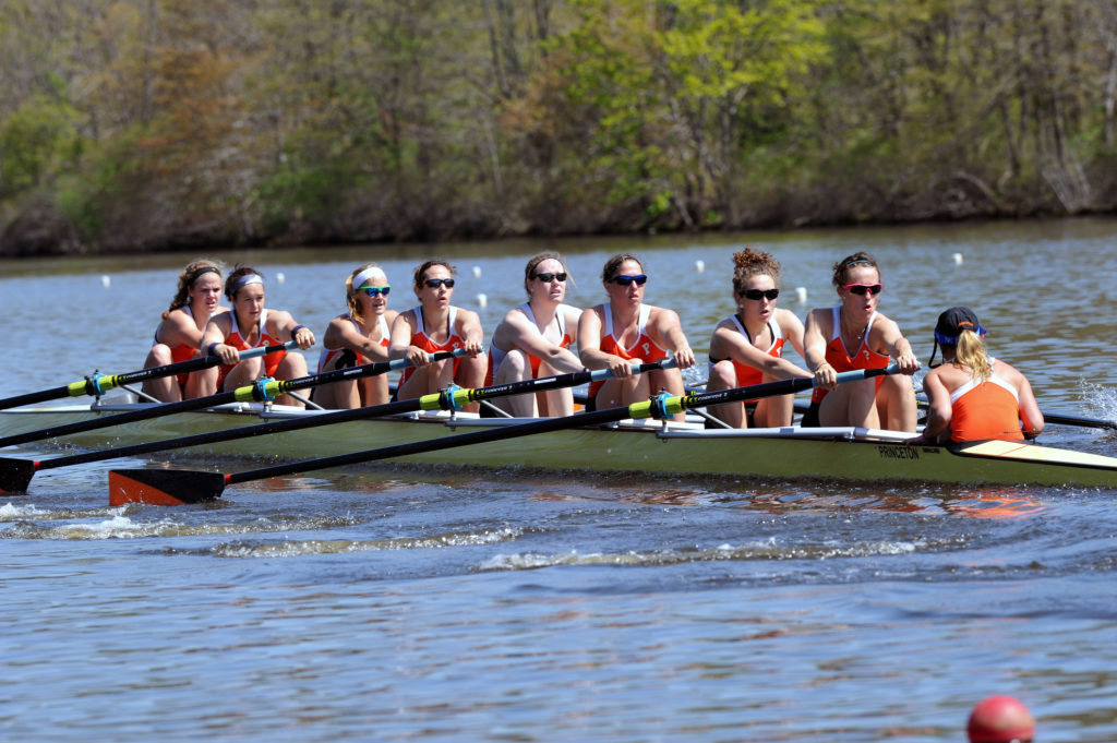 A group of people rowing a boat in the water