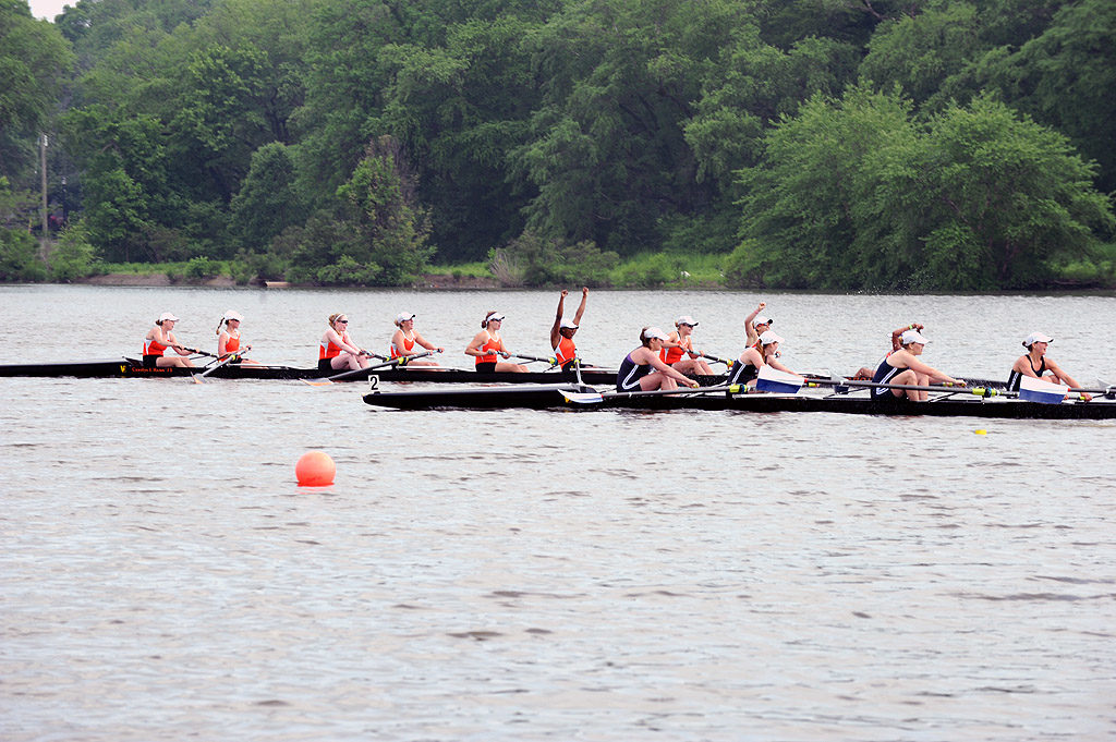 A group of people rowing a boat floating on a body of water