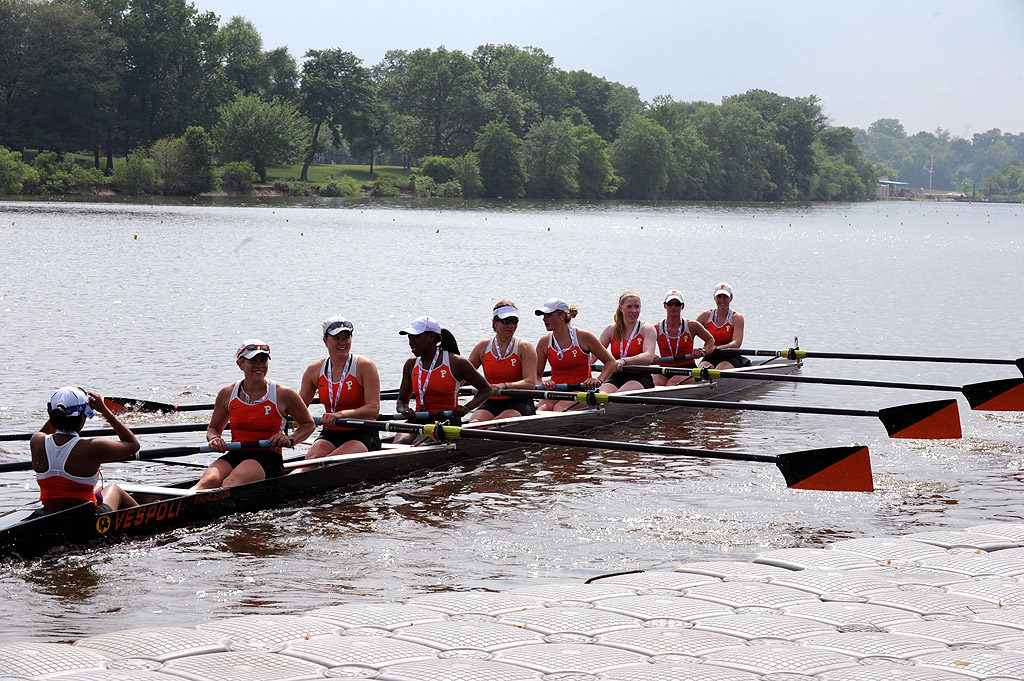 A group of people rowing a boat in a body of water