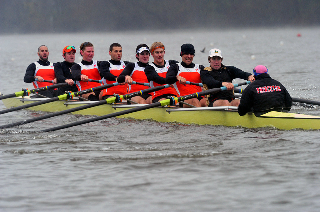 A group of people rowing a boat in the water