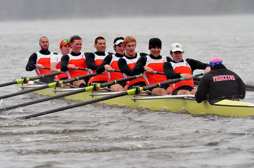 A group of people rowing a boat in the water