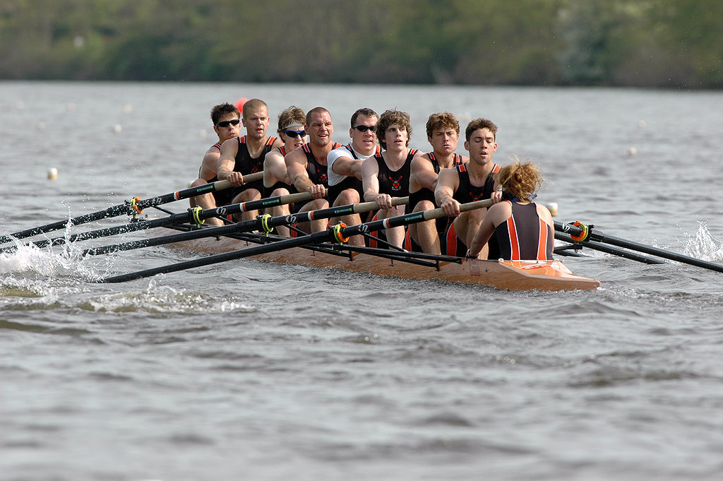 A group of people rowing a boat in a body of water